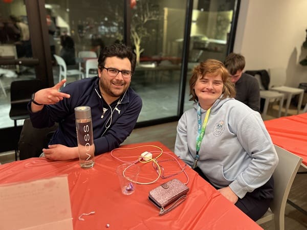 Two Main Street ambassadors sitting at a table and smiling at the camera