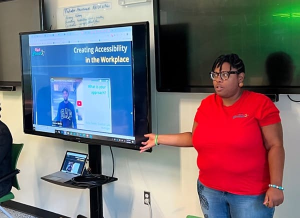 Main Street ambassador presenting in front of a group using a slide presentation
