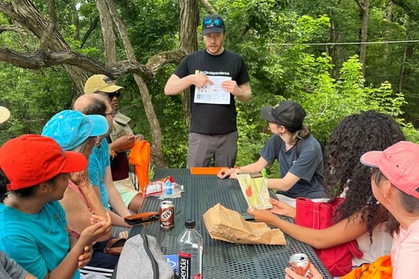 Ryan McNulty from The Arc of Northern Virginia provides guidance to participants seated at picnic table during Main Street's Connect and Go series
